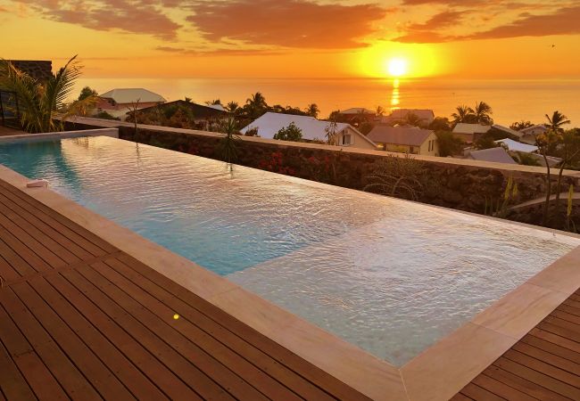 La piscine illuminée par le coucher de soleil sur l’océan – Villa Naézora, villa 10 personnes avec piscine à Saint-Gilles-les-Bains, La Réunion